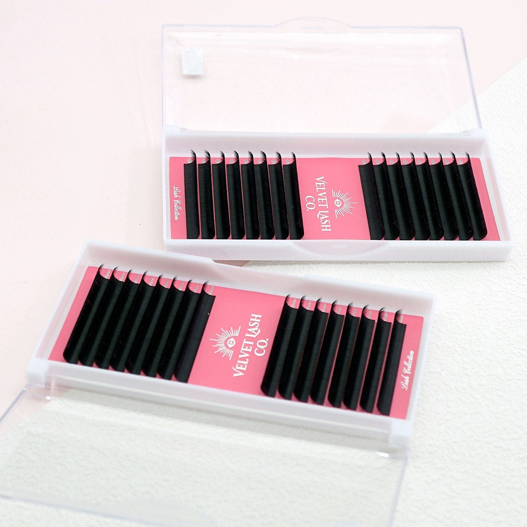 Two boxes of false eyelashes with pink labels on a white background