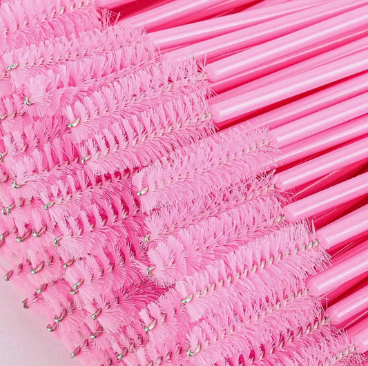 Pink disposable nylon lash spoolies with flexible brush heads by Velvet Lash Co. for brushing, separating, and styling eyelash extensions.